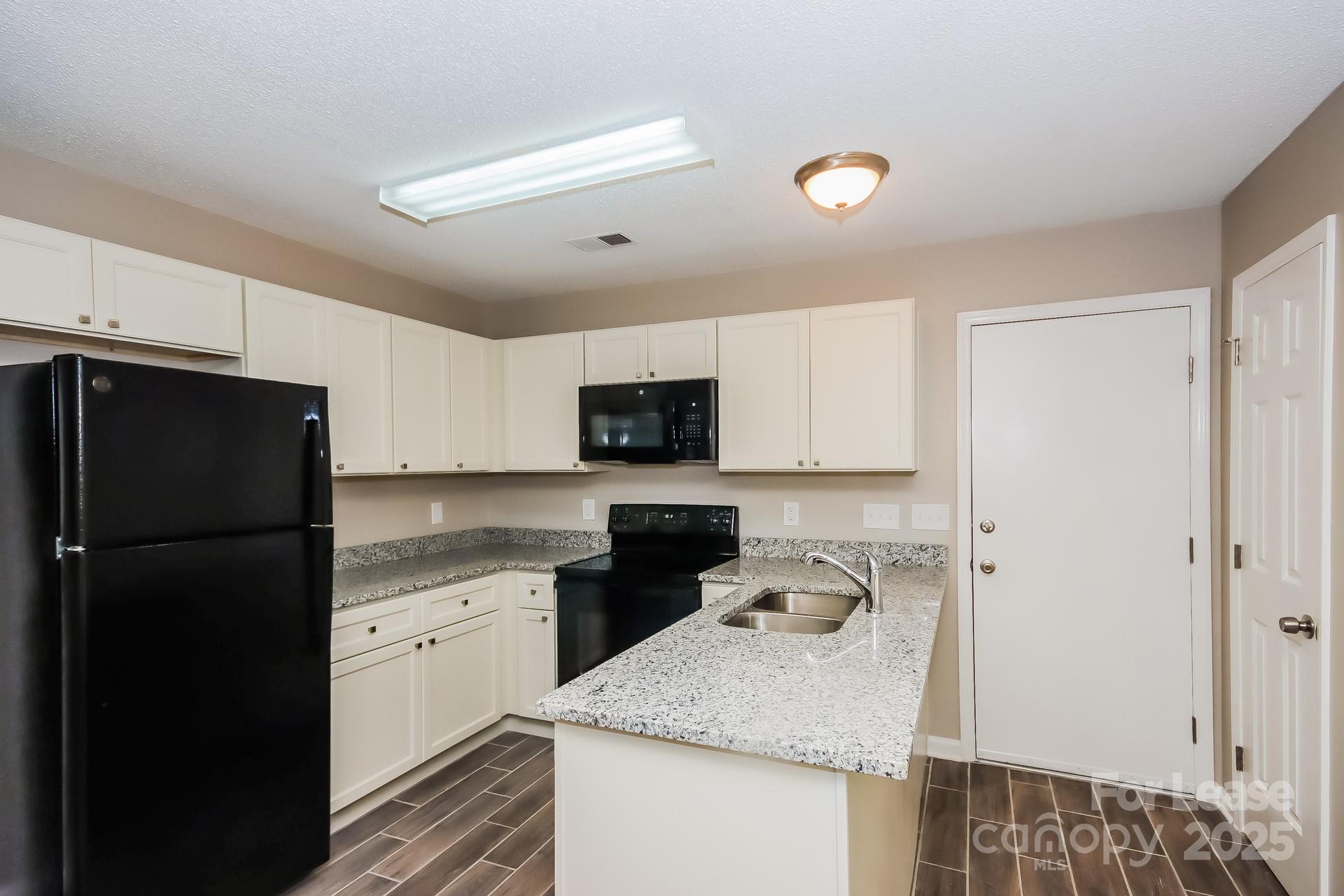 9216 Torrence Crossing Drive Huntersville, NC 28078 - Photo 7 of 17 a kitchen with a sink a stove and refrigerator