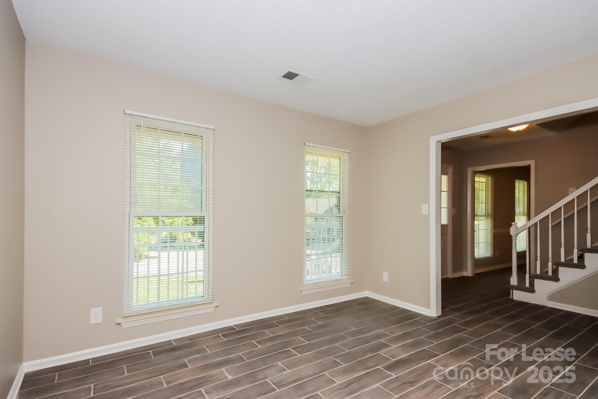 9216 Torrence Crossing Drive Huntersville, NC 28078 - Photo 9 of 17 a view of an empty room with wooden floor and a window
