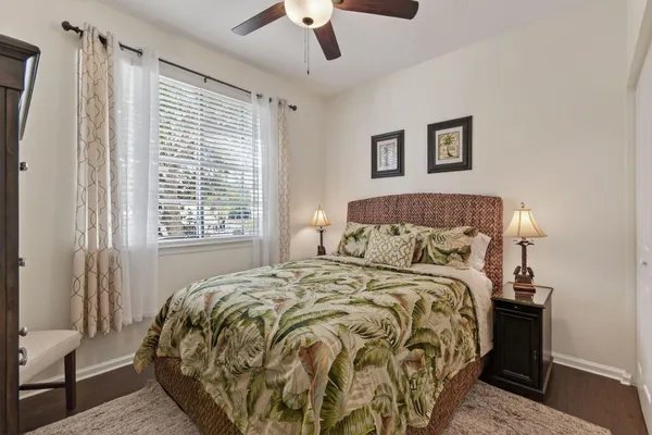 a bed sitting in a bedroom next to a window and a chair