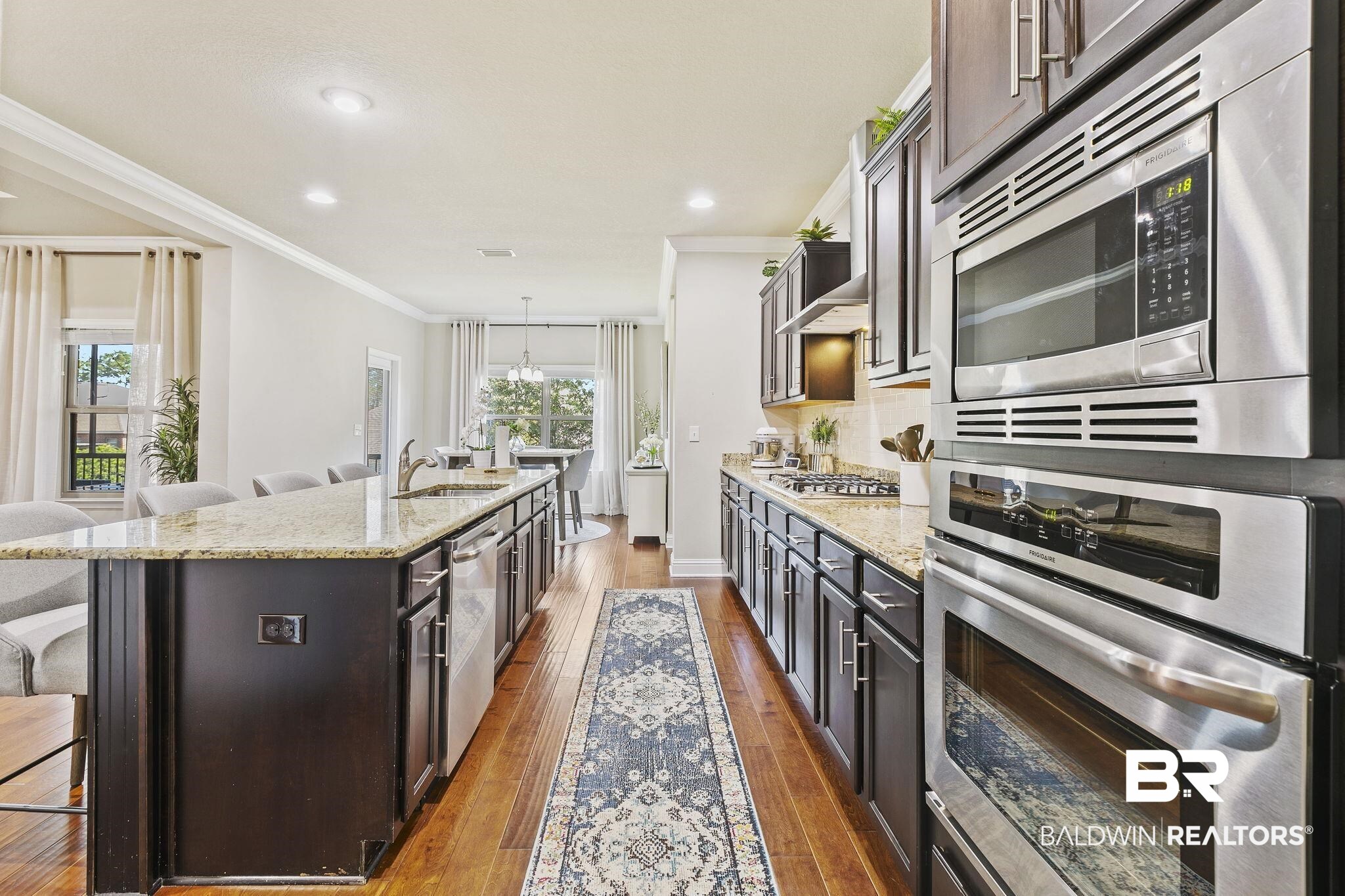 31500 Spoonbill Road Daphne, AL 36527 - Photo 21 of 85 Kitchen with a healthy amount of sunlight, appliances with stainless steel finishes, a center island with sink, and a breakfast bar