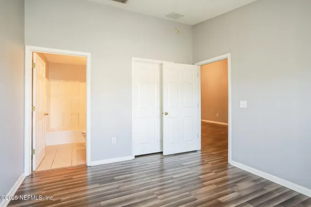 a view of an empty room with wooden floor