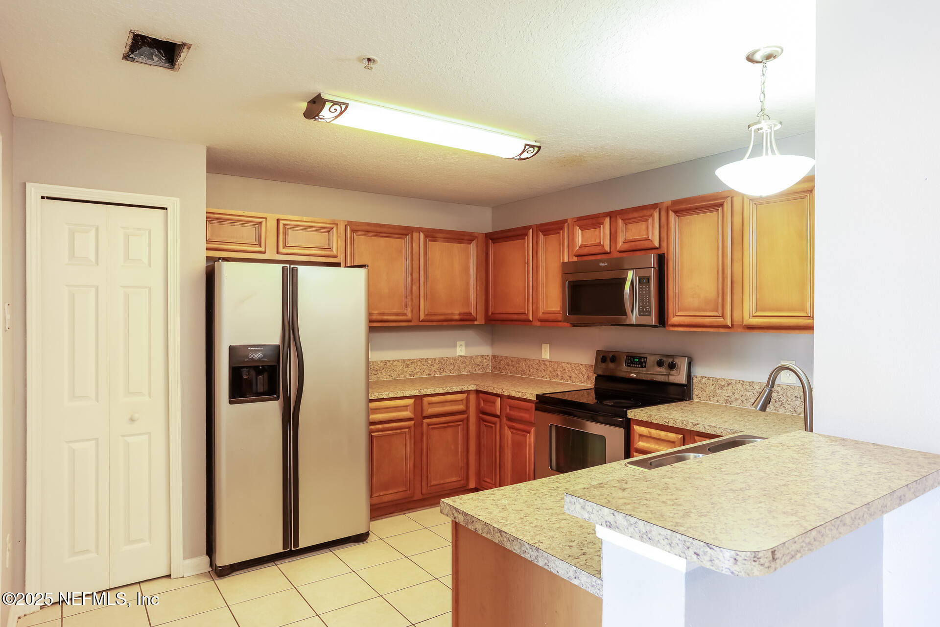 6860 Skaff Avenue, Unit 29 Jacksonville, FL 32244 - Photo 8 of 18 a kitchen that has a refrigerator a sink and cabinets