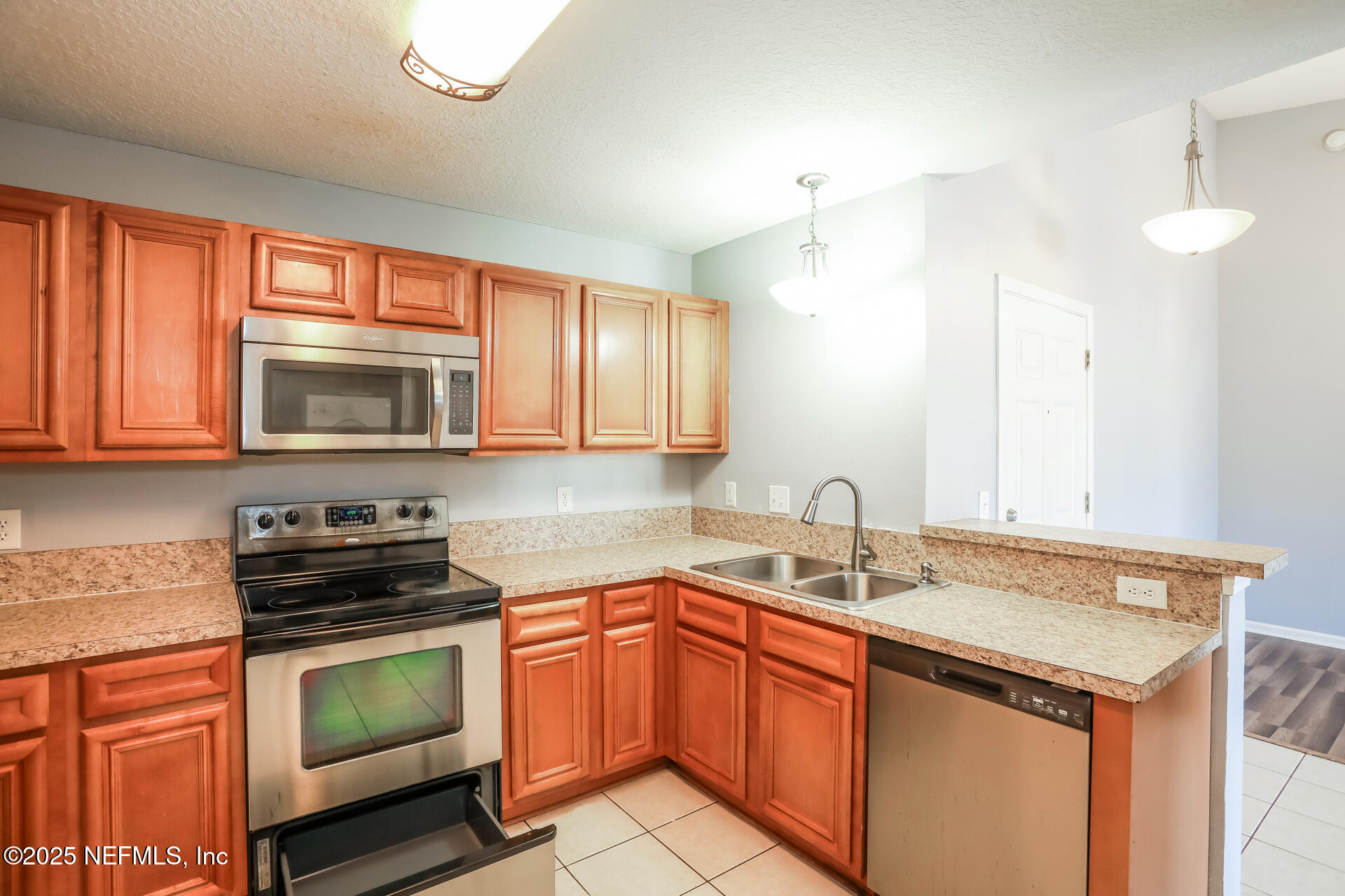 6860 Skaff Avenue, Unit 29 Jacksonville, FL 32244 - Photo 9 of 18 a kitchen with granite countertop a sink stainless steel appliances and cabinets
