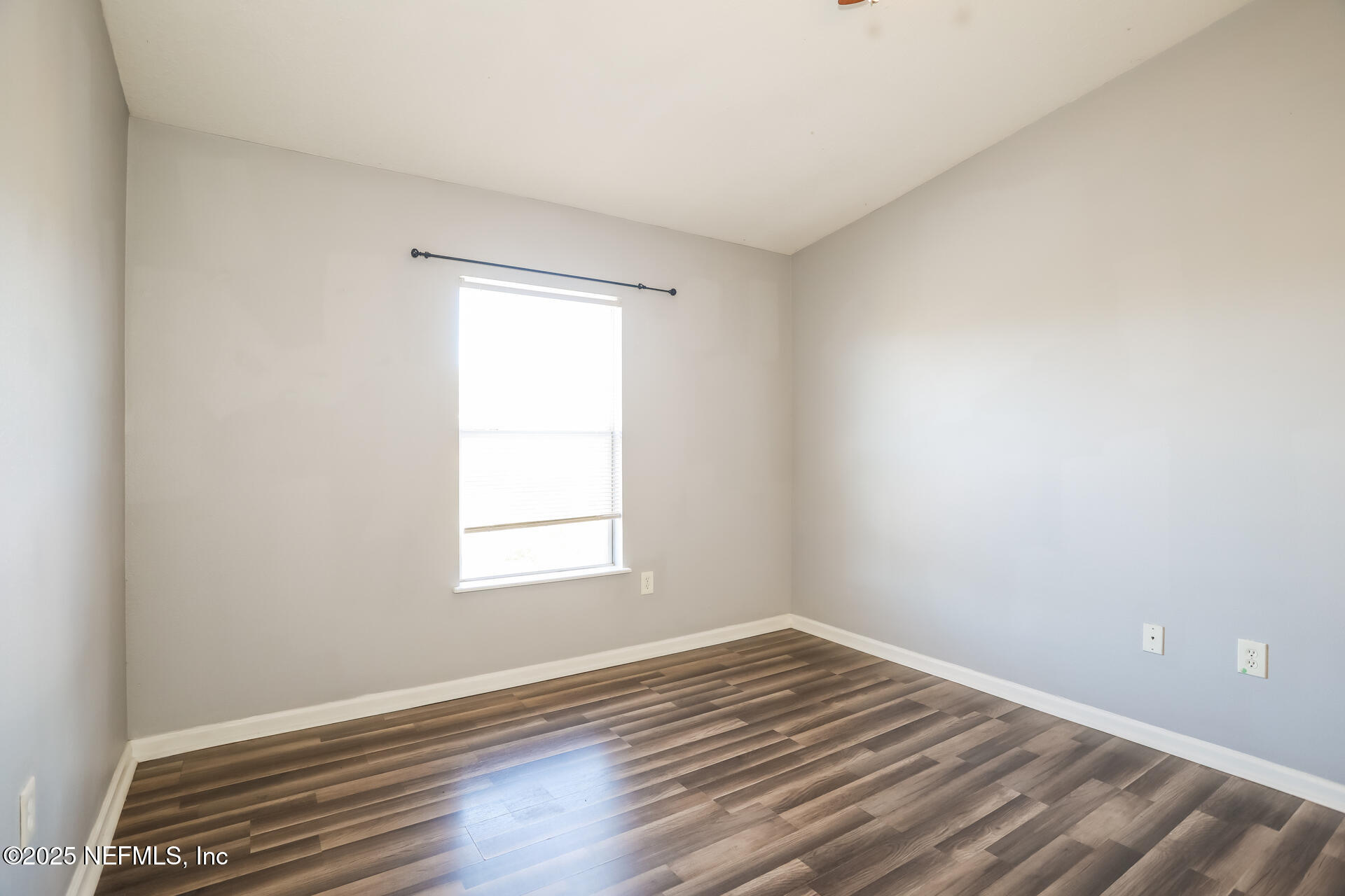 6860 Skaff Avenue, Unit 29 Jacksonville, FL 32244 - Photo 10 of 18 an empty room with wooden floor and windows