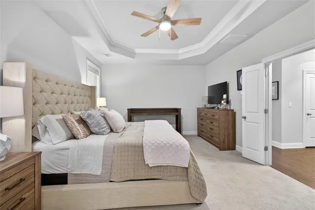a living room with furniture a ceiling fan and a flat screen tv
