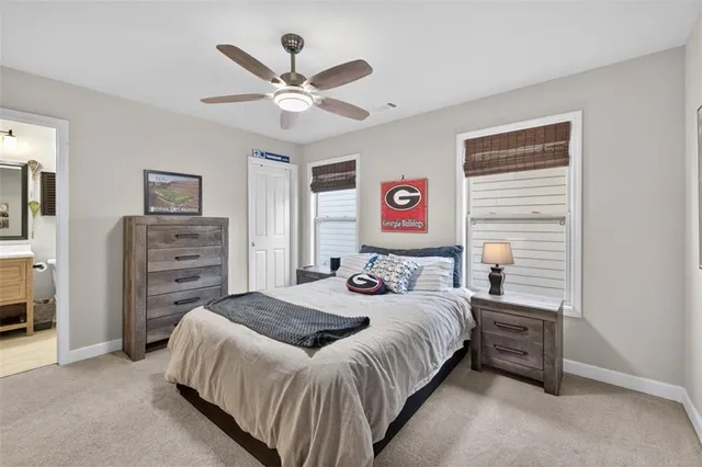 a bedroom with a bed a dresser and a chandelier