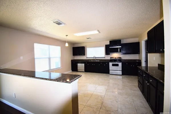 a view of a kitchen with a stove wooden floor and a kitchen