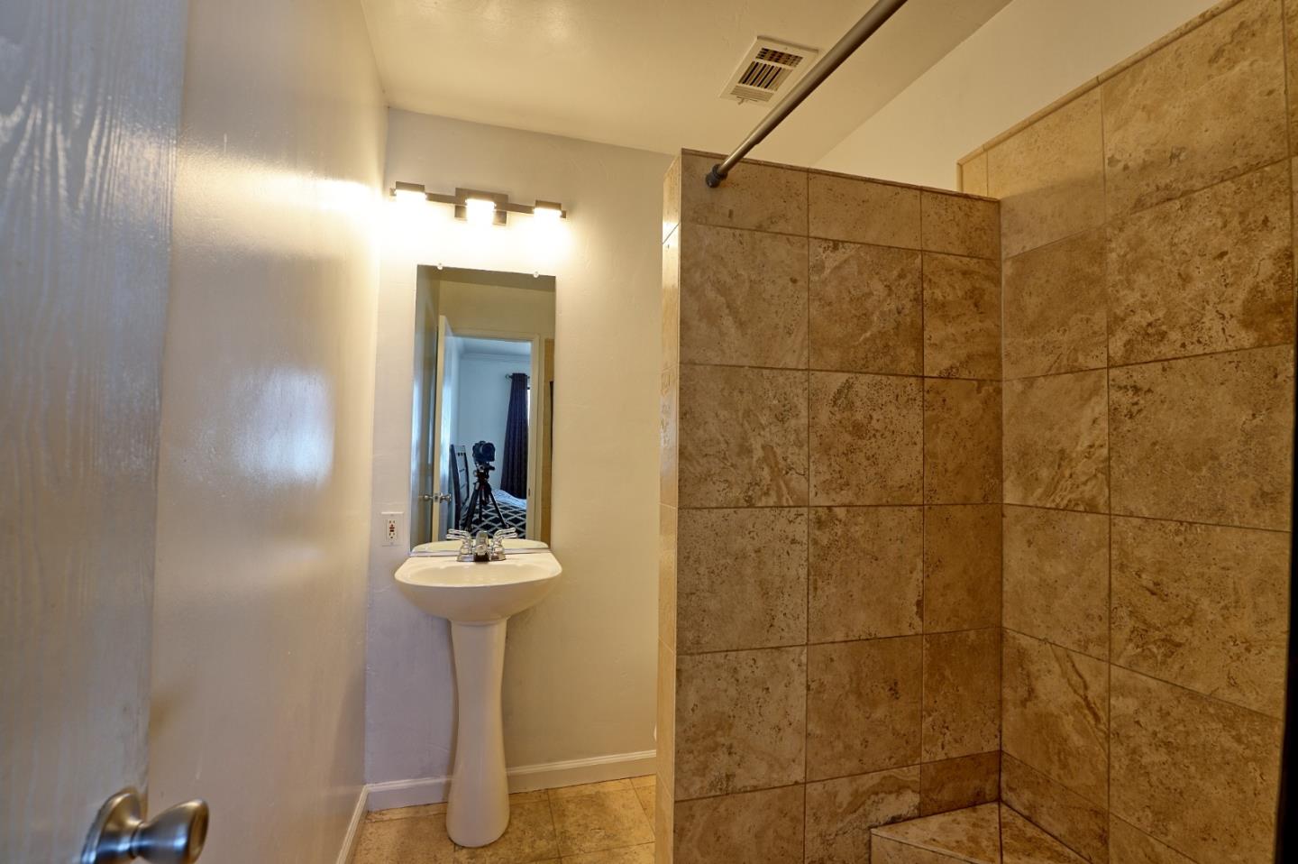 801 Nash Road, Unit I2 Hollister, CA 95023 - Photo 14 of 26 a bathroom with a sink a mirror and shower