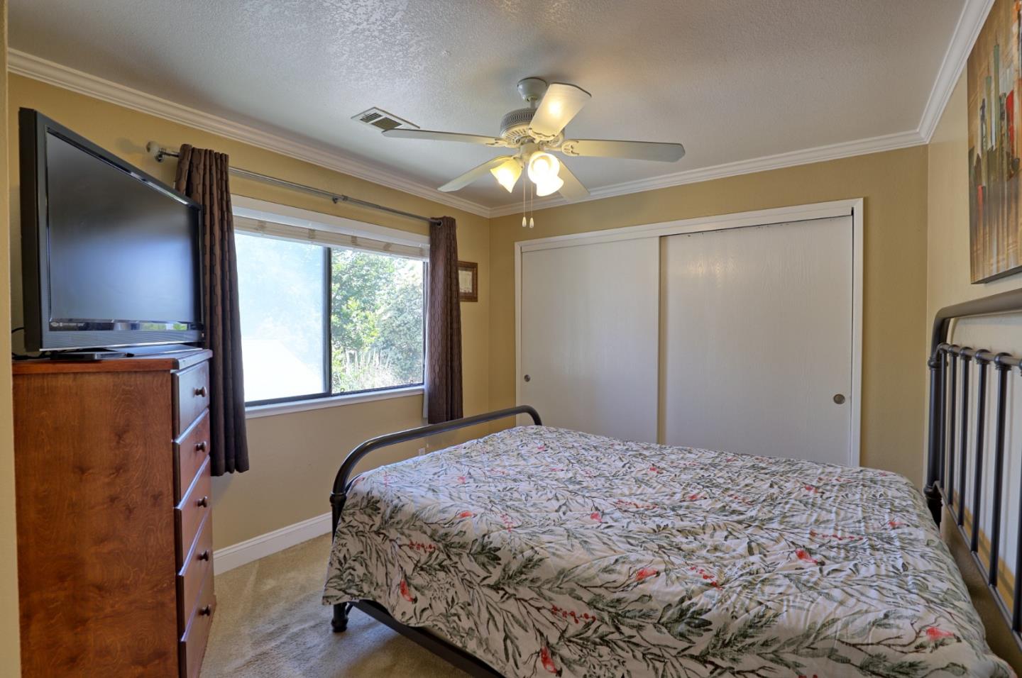 801 Nash Road, Unit I2 Hollister, CA 95023 - Photo 18 of 26 a bedroom with a bed and a chandelier