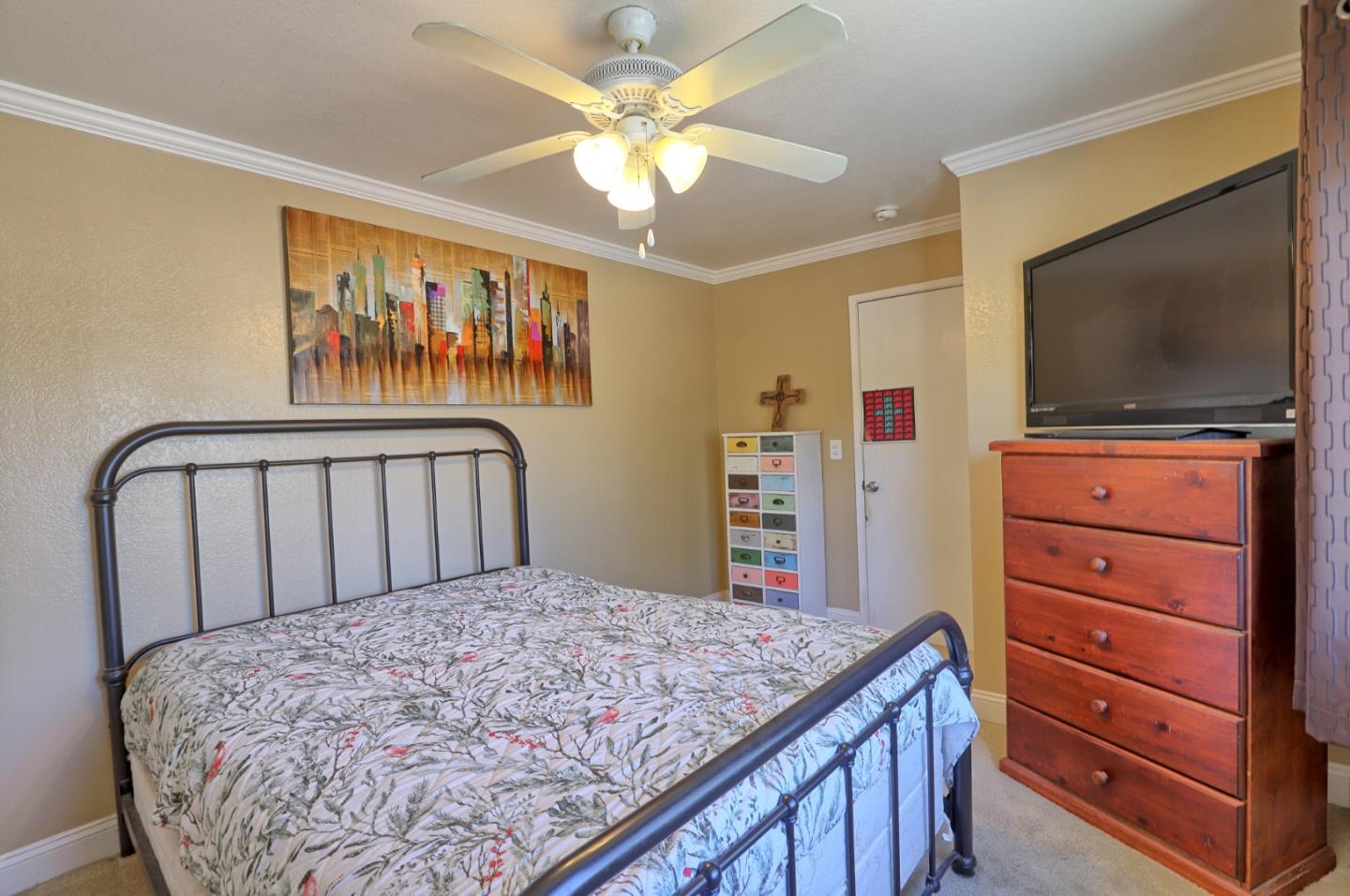 801 Nash Road, Unit I2 Hollister, CA 95023 - Photo 19 of 26 a bedroom with a bed and a flat screen tv