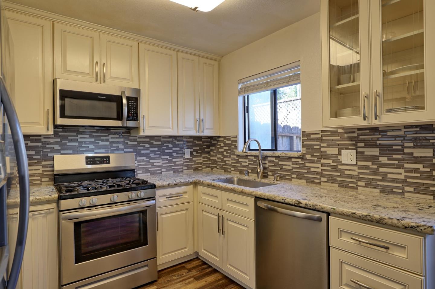 801 Nash Road, Unit I2 Hollister, CA 95023 - Photo 8 of 26 a kitchen with granite countertop a stove sink and microwave