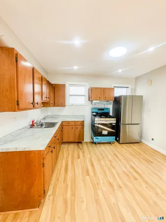 a kitchen with stainless steel appliances kitchen island granite countertop a refrigerator and a stove