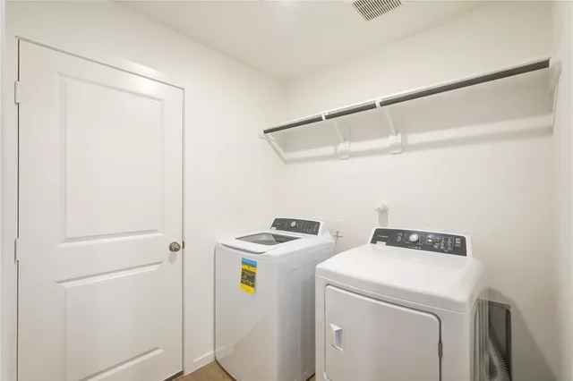 a view of a kitchen with refrigerator and wooden floor