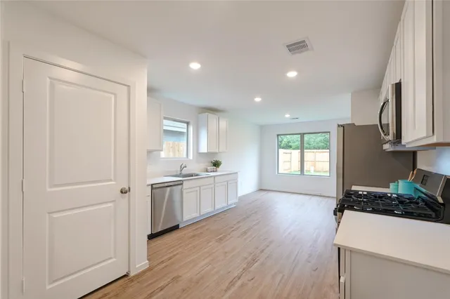 an empty room with wooden floor and windows