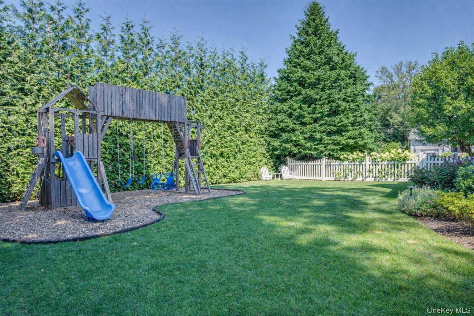 100 Dearborn Avenue Rye, NY 10580 - Photo 39 of 49 a view of a backyard with a wooden fence and a slide