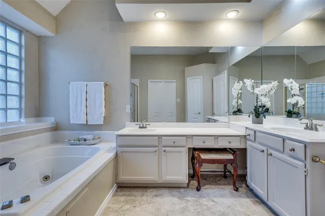 a spacious bathroom with a granite countertop sink a toilet a mirror and bathtub