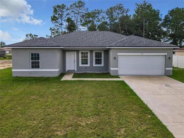 a front view of a house with a garden and yard