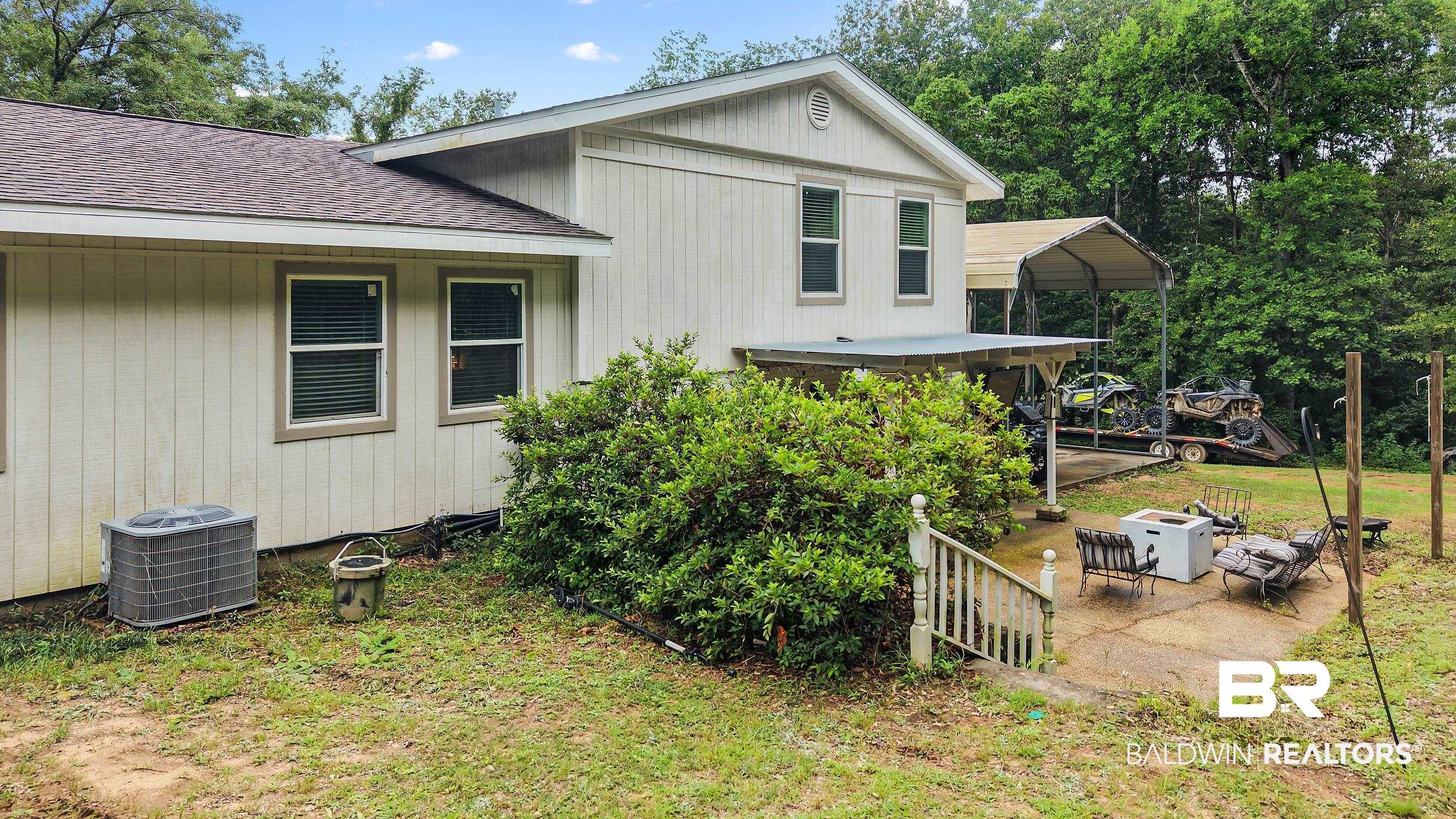 33129 Antietam Road Lillian, AL 36549 - Photo 24 of 31 Exterior featuring light-colored siding, multiple windows with blinds, and a brown shingled roof