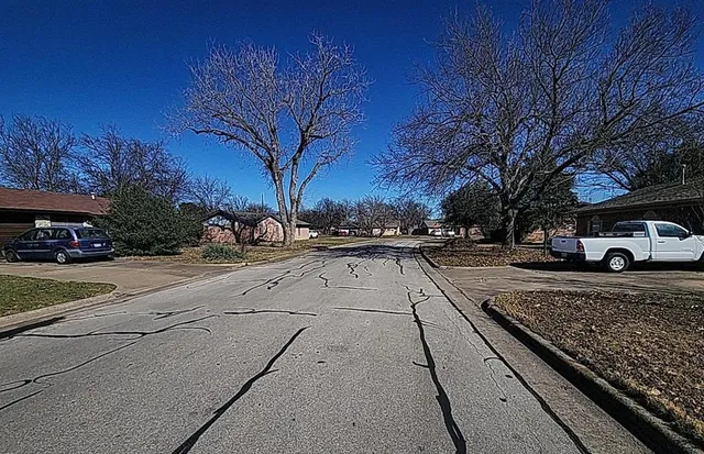 a view of city street with a parked car