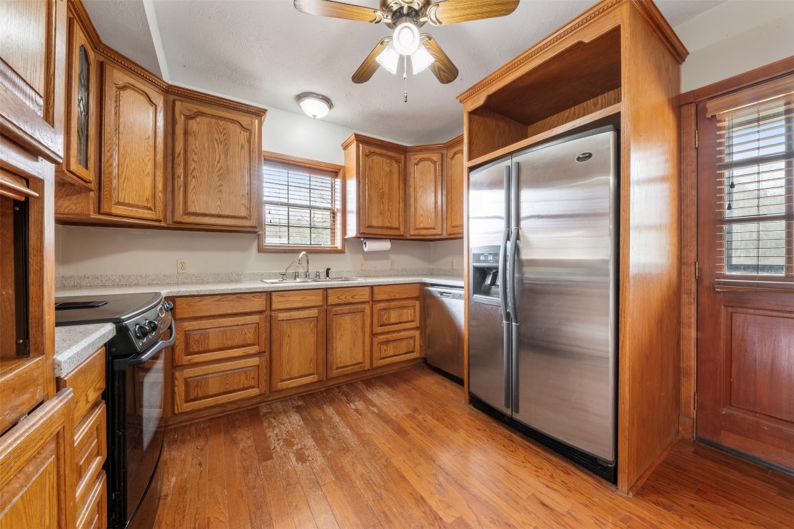 33349 Interstate 10 Hankamer, TX 77560 - Photo 8 of 28 a kitchen with stainless steel appliances granite countertop a refrigerator a sink dishwasher a stove and white countertops with wooden floor