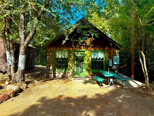 a view of backyard with a table and chairs under an umbrella