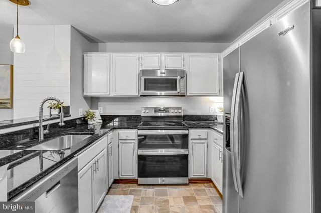 a kitchen with stainless steel appliances granite countertop a stove and a refrigerator