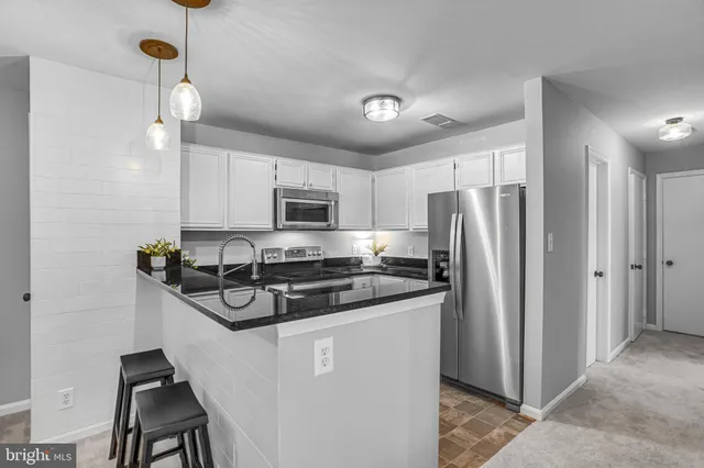 a kitchen with stainless steel appliances a sink stove and refrigerator