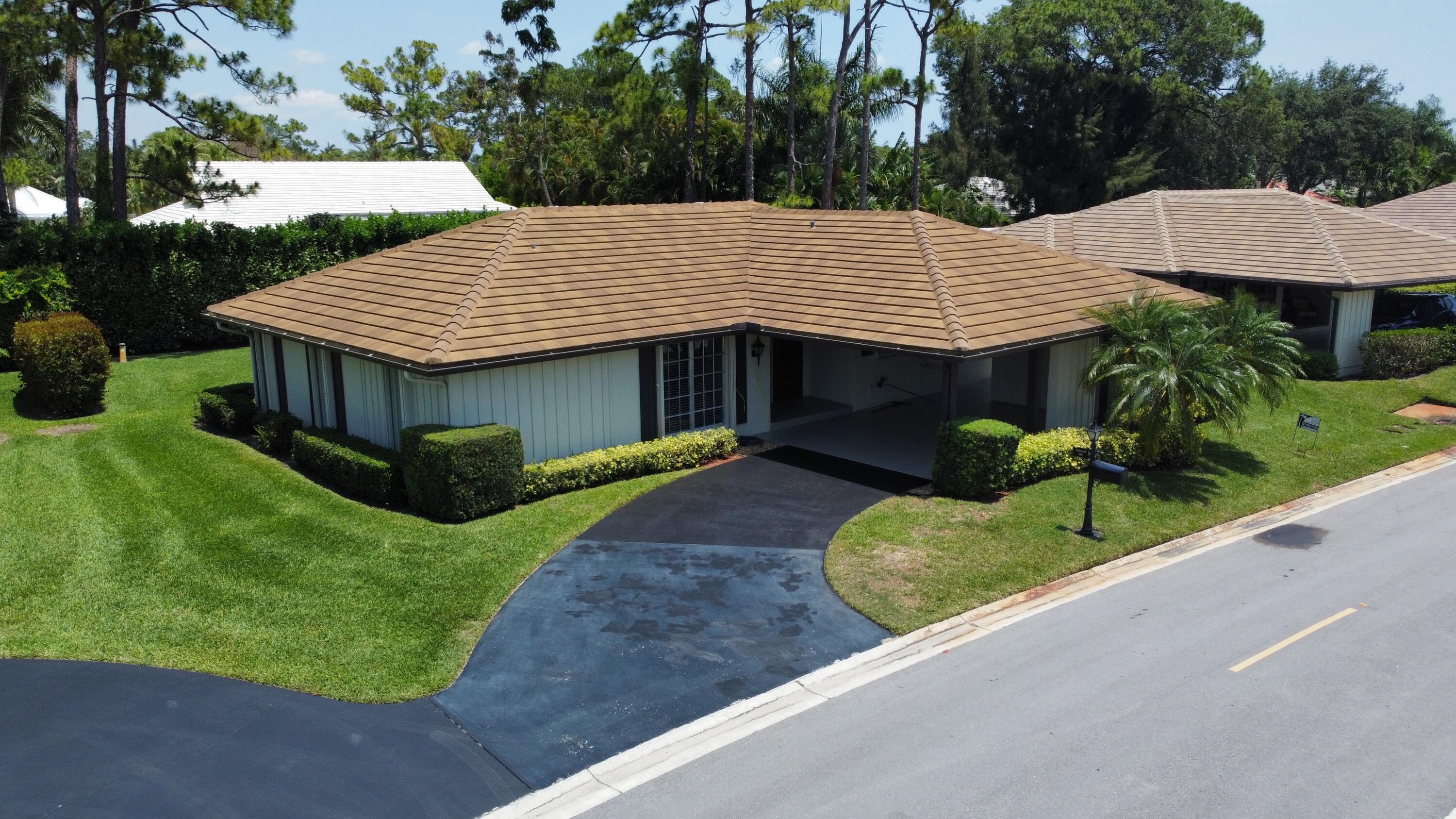 a view of a house with a yard and potted plants