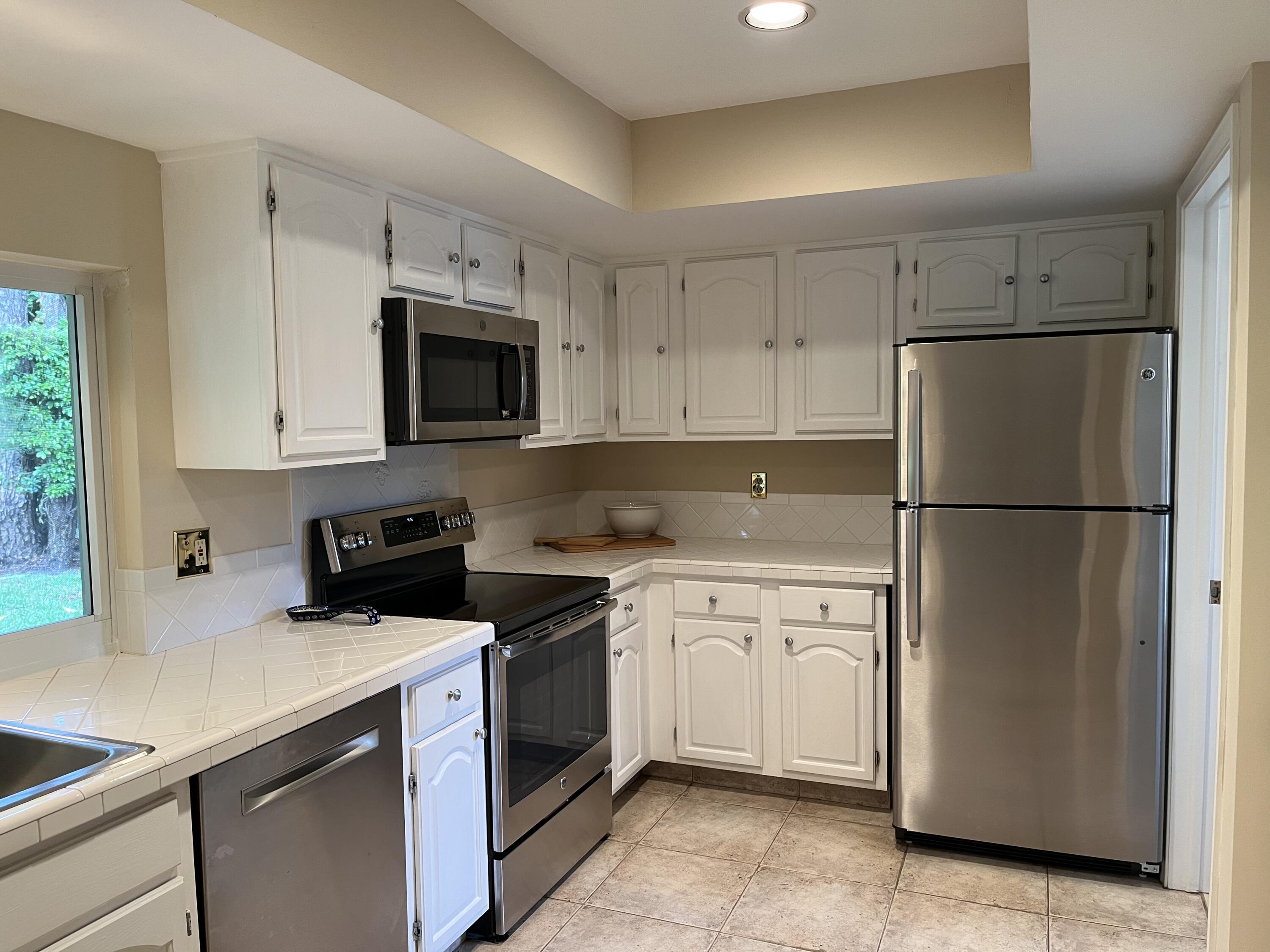 493 Forestview Drive Atlantis, FL 33462 - Photo 13 of 21 a kitchen with cabinets stainless steel appliances and a counter space