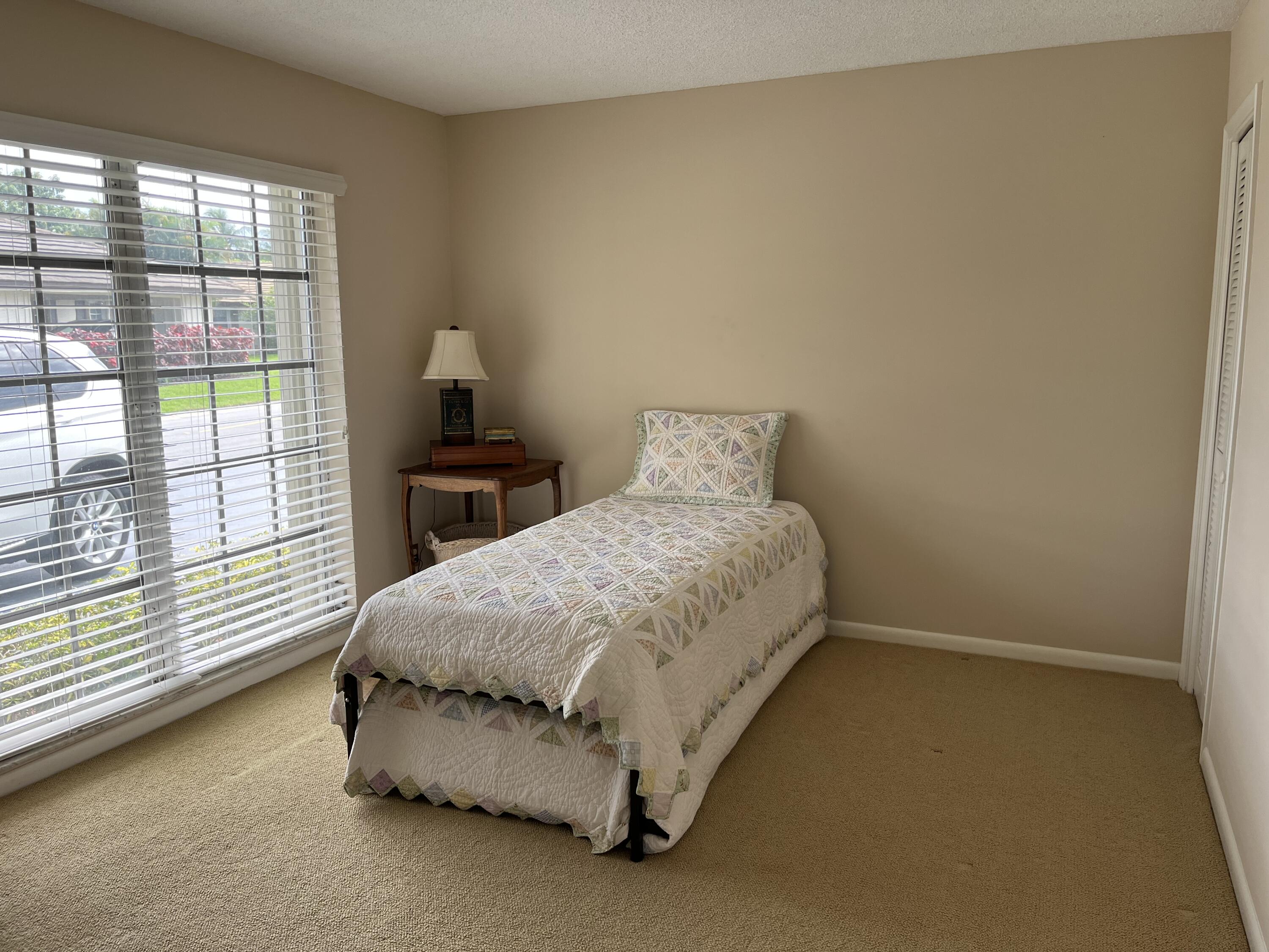 493 Forestview Drive Atlantis, FL 33462 - Photo 18 of 21 a bedroom with a bed and window