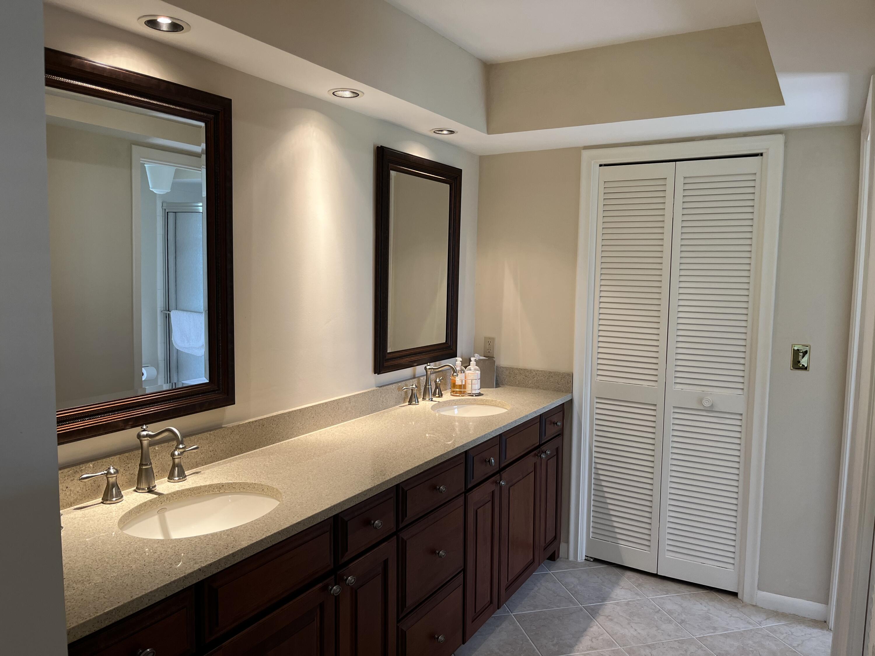 493 Forestview Drive Atlantis, FL 33462 - Photo 19 of 21 a bathroom with a double vanity sink and a mirror