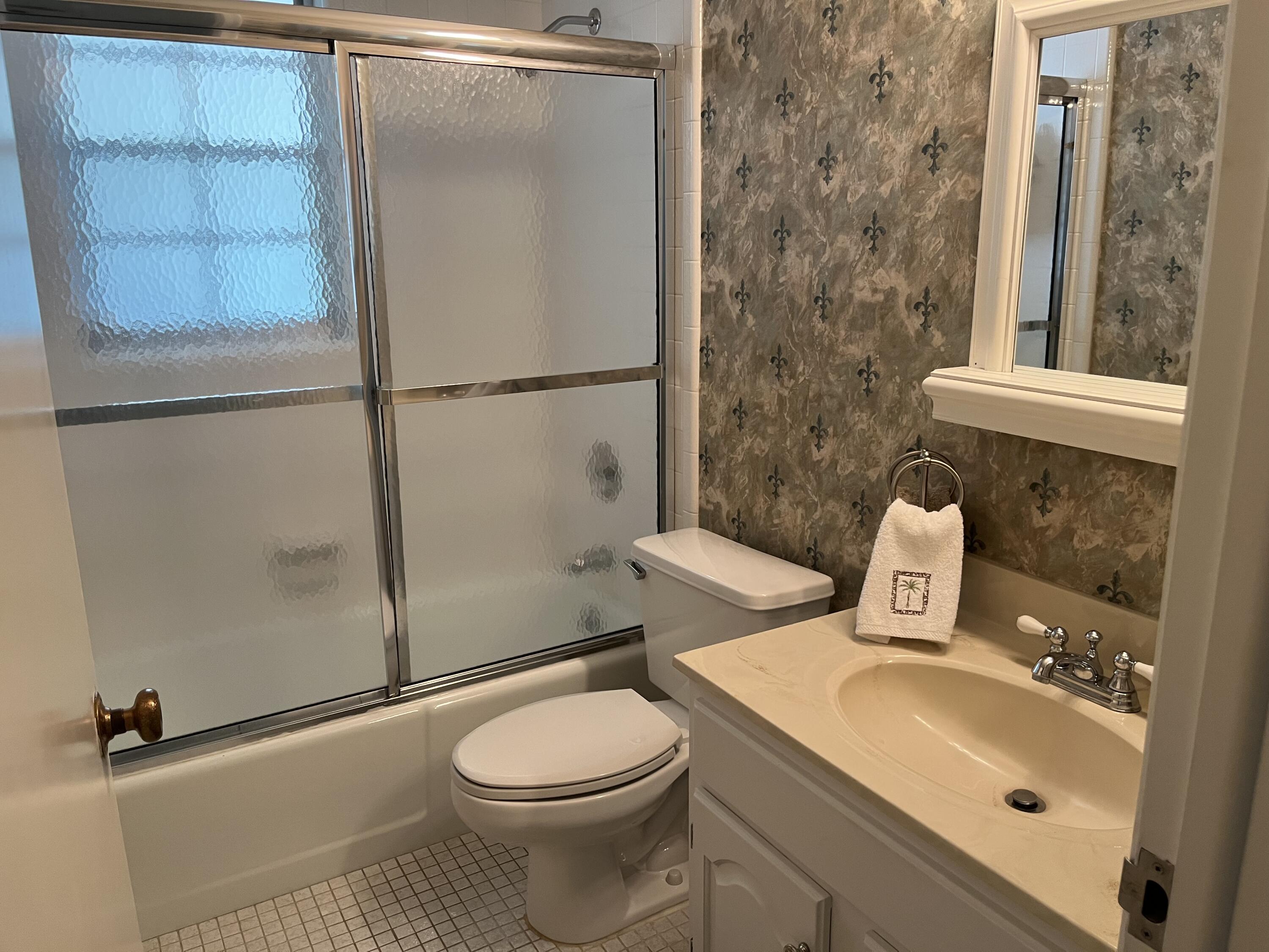 493 Forestview Drive Atlantis, FL 33462 - Photo 20 of 21 a white toilet sitting next to a bathroom sink