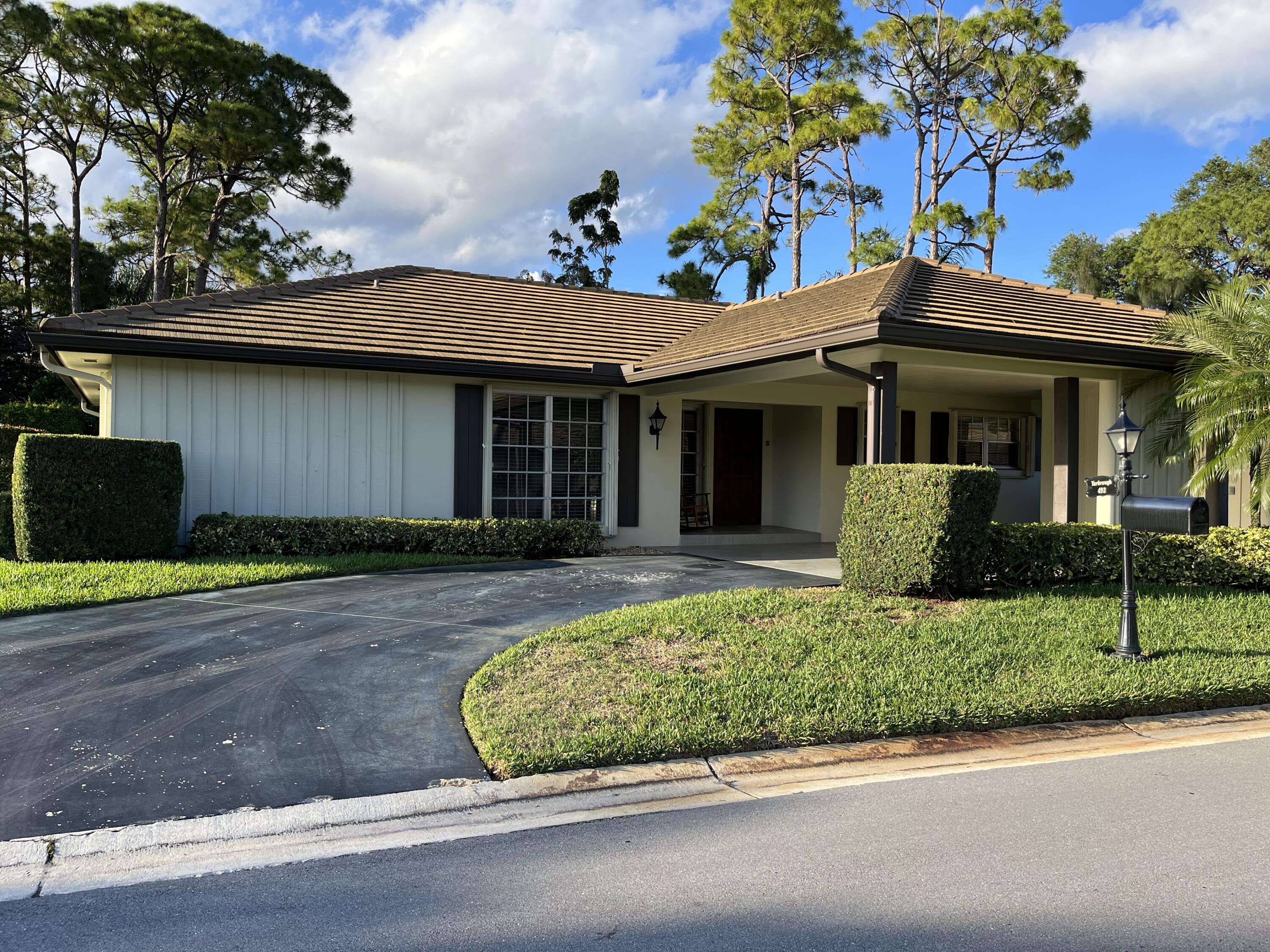 493 Forestview Drive Atlantis, FL 33462 - Photo 4 of 21 a front view of a house with a garden