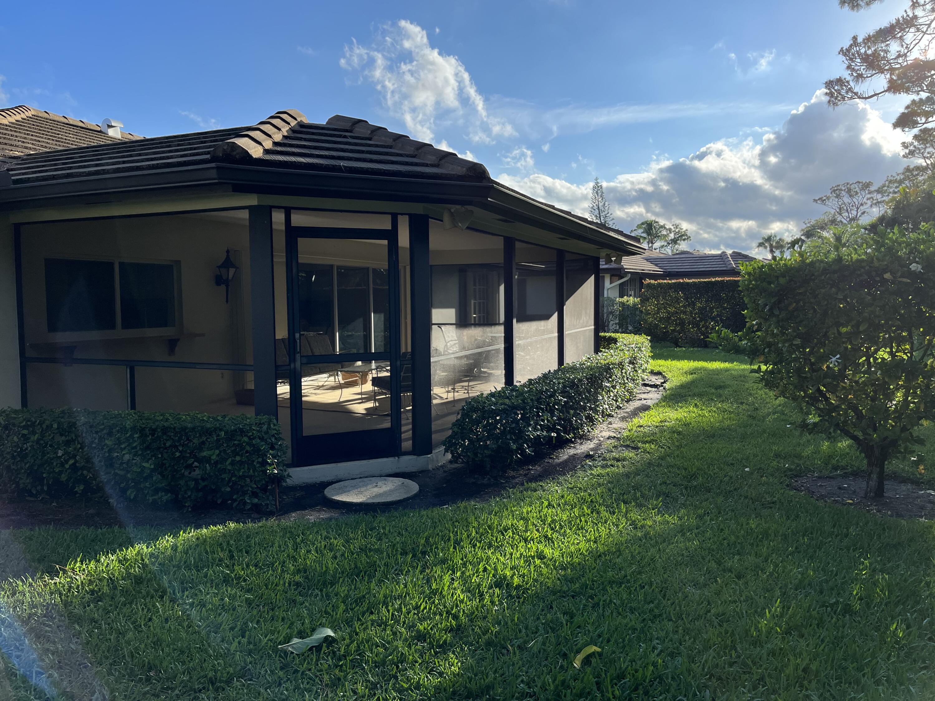 493 Forestview Drive Atlantis, FL 33462 - Photo 6 of 21 a front view of a house with a garden and plants