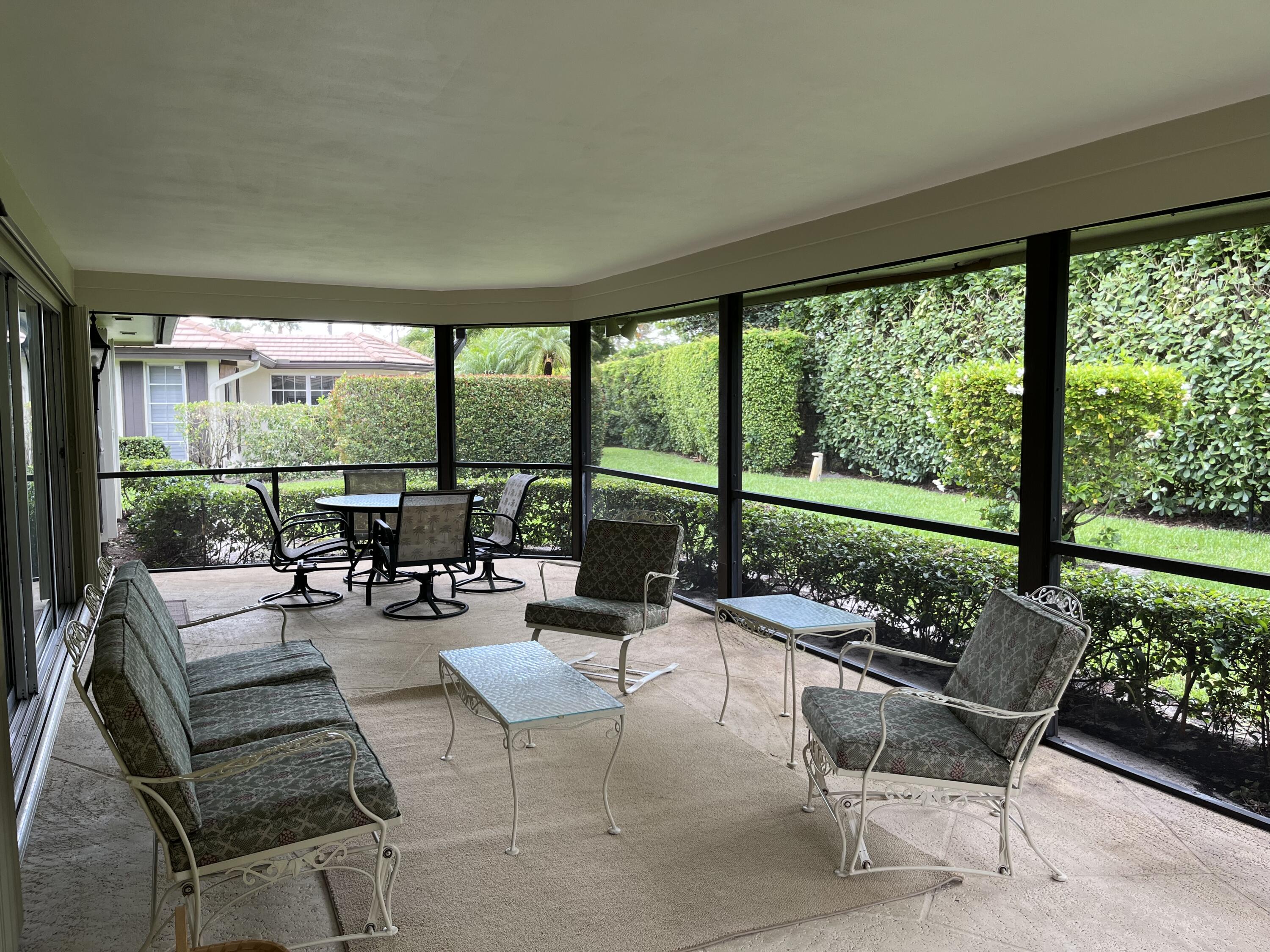493 Forestview Drive Atlantis, FL 33462 - Photo 8 of 21 a living room with patio furniture and a garden