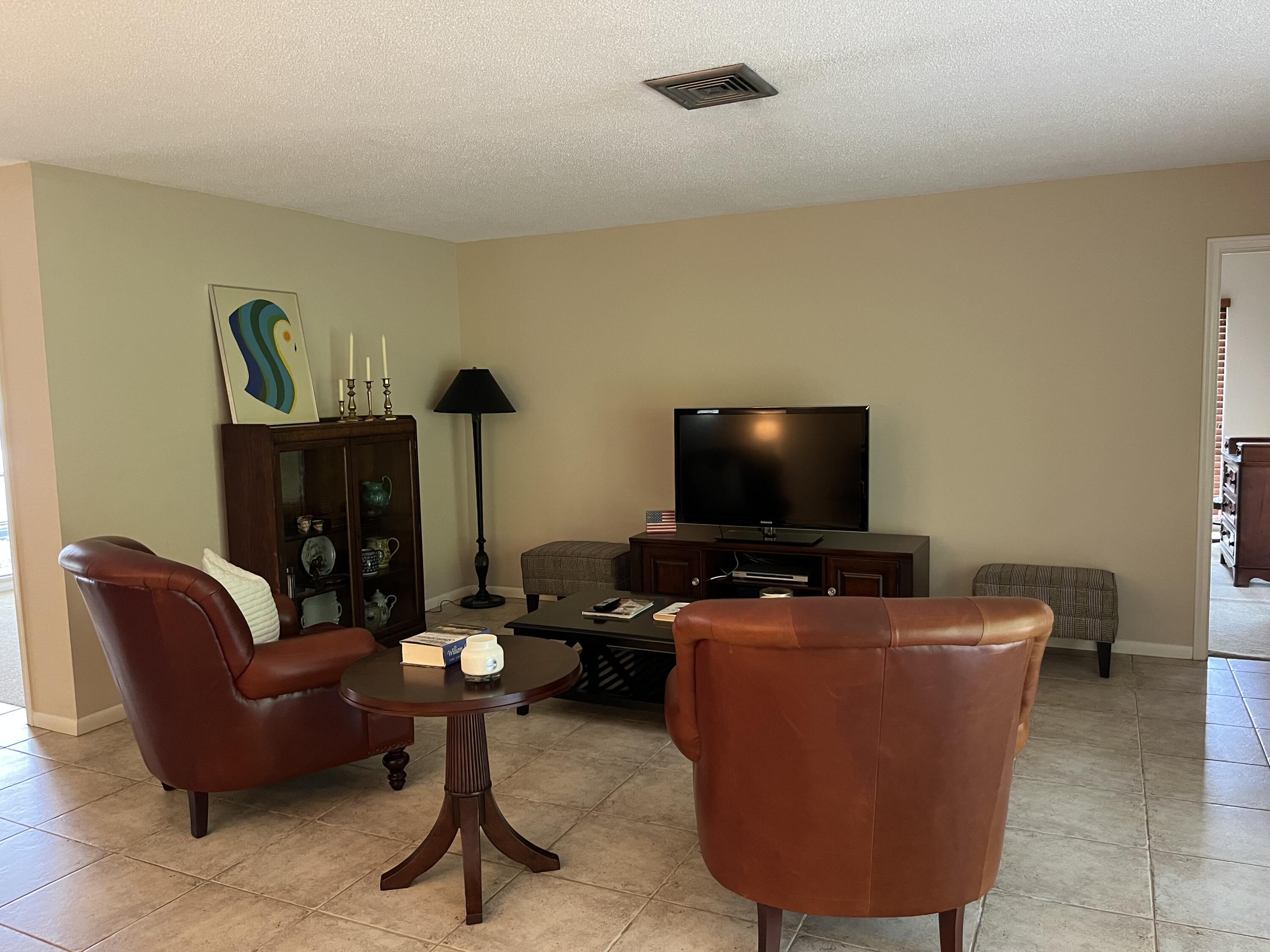 493 Forestview Drive Atlantis, FL 33462 - Photo 10 of 21 a living room with furniture and a flat screen tv