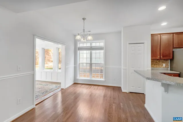 an empty room with windows and chandelier fan