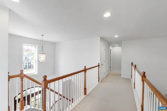 a view of a white house with a big yard and potted plants