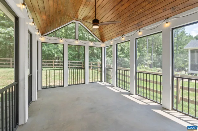 an empty room with wooden floor a fireplace and a window