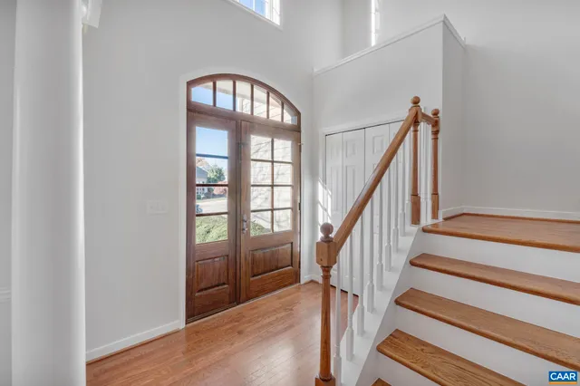 a view of empty room with stairs and wooden floor