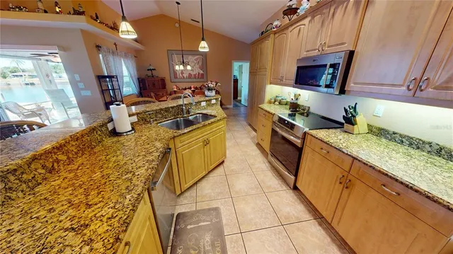a kitchen with stainless steel appliances granite countertop a sink stove and cabinets