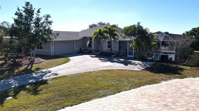 an aerial view of a house with swimming pool and outdoor seating