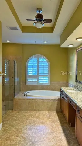 a bathroom with a tub a sink and a mirror