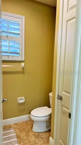 a bathroom with a toilet and a window