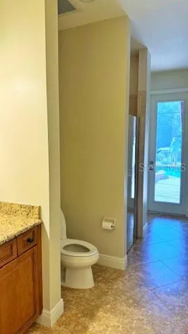 a bathroom with a granite countertop toilet and a shower