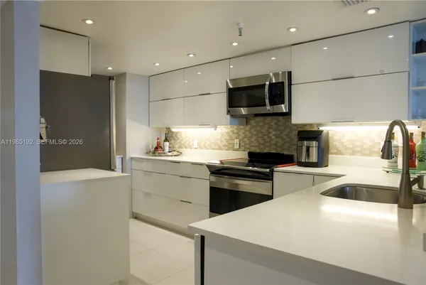 a kitchen with stainless steel appliances granite countertop a sink and a refrigerator