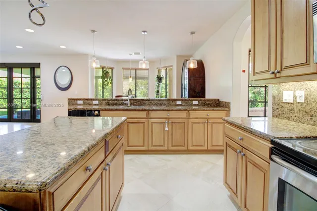 a kitchen with stainless steel appliances granite countertop a stove sink and cabinets