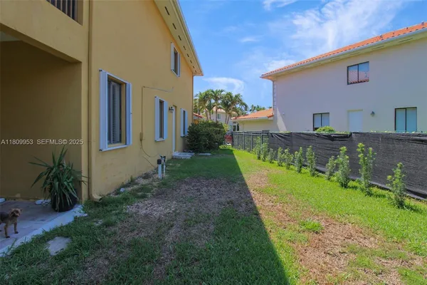 a living room with patio furniture and a garden