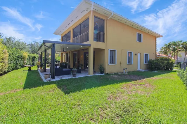 a view of a patio with table and chairs potted plants and floor to ceiling window