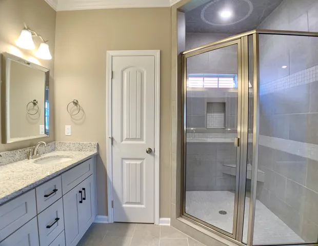 a bathroom with a granite countertop sink mirror and shower